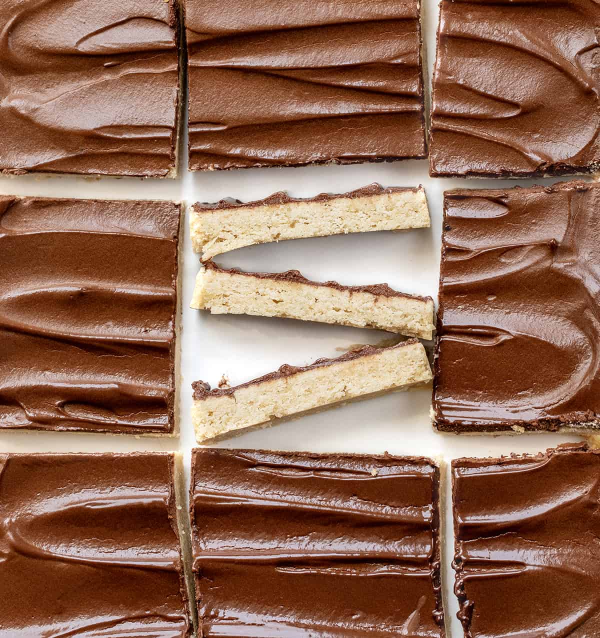 Cinnamon Shortbread Bars on a White Counter with the Center Bar Cut up and Put on its Side. 